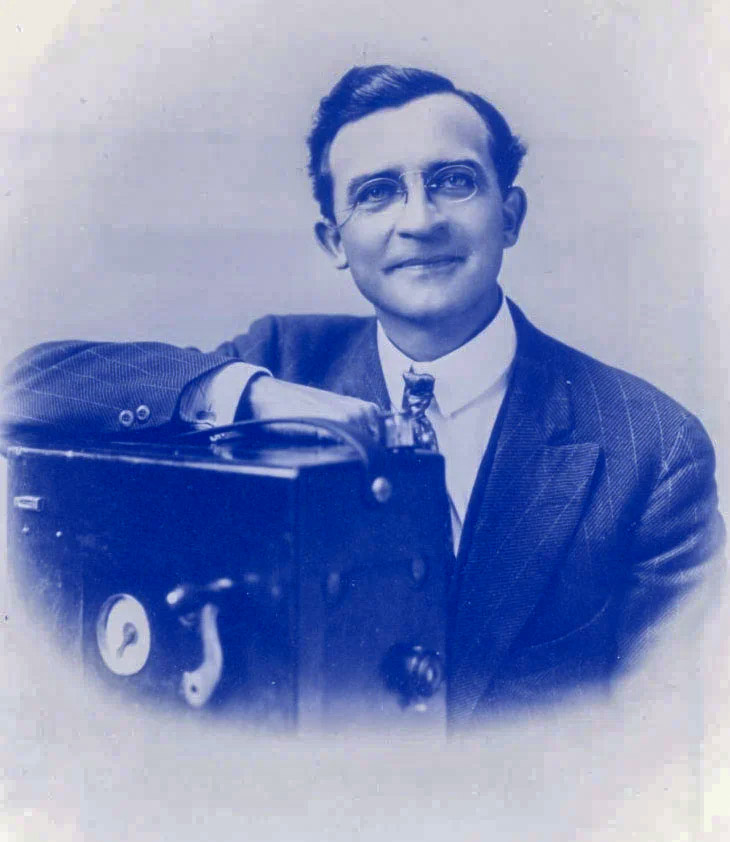 Portrait of Herman Adolf DeVry with early motion picture apparatus