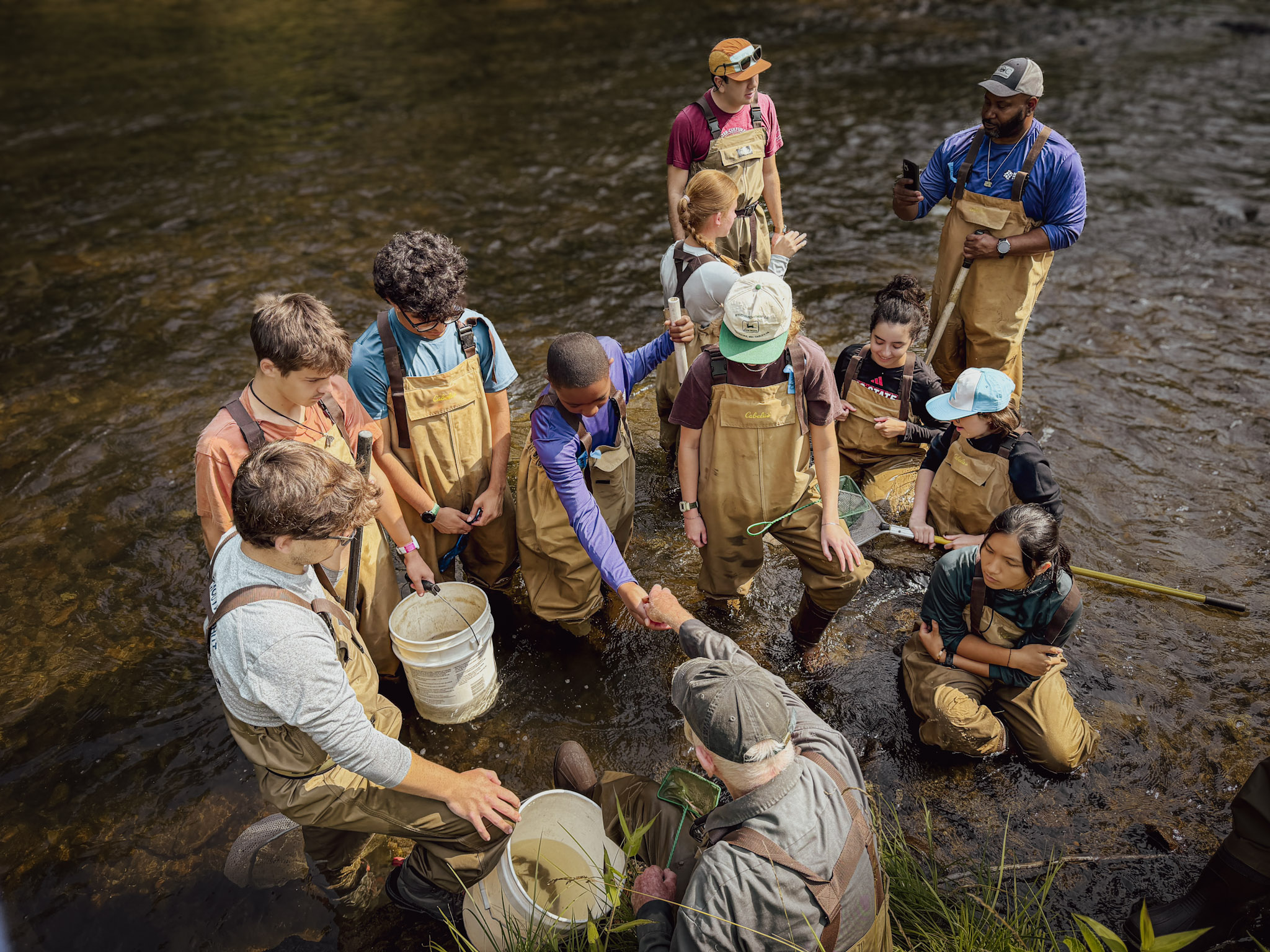 The field team wades into the Cullasaja River with electrofishing equipment during the summer biomonitoring survey.